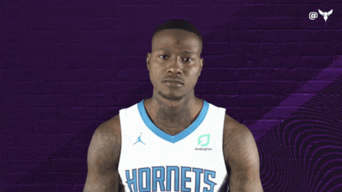 A Basketball Player Wearing A Hornets Jersey Points Up GIF