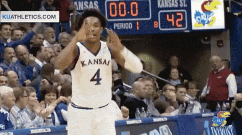 A Basketball Player Wearing A Kansas Jersey Number 4 Stands In Front Of A Crowd GIF