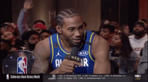 A Basketball Player Wearing A Kia Jersey Talks Into A Microphone In Front Of A Crowd GIF