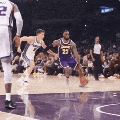 A Basketball Player Wearing A Lakers Jersey Is Dribbling The Ball GIF