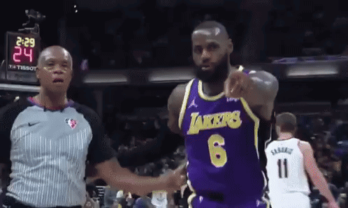 A Basketball Player Wearing A Lakers Jersey Is Pointing At The Referee GIF