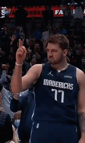 A Basketball Player Wearing A Mavericks Jersey Points To The Crowd GIF
