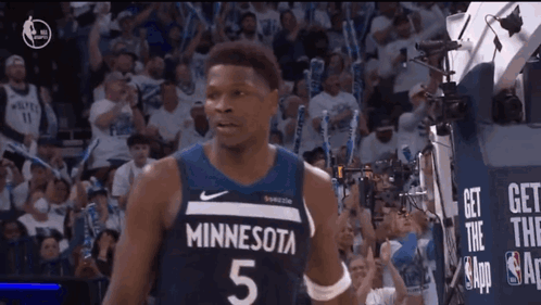 A Basketball Player Wearing A Minnesota Jersey Is Standing In Front Of A Crowd GIF