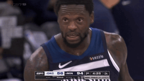 A Basketball Player Wearing A Minnesota Jersey Stands In The Stands GIF