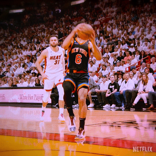 A Basketball Player Wearing A New York Jersey Is Jumping To Catch The Ball GIF