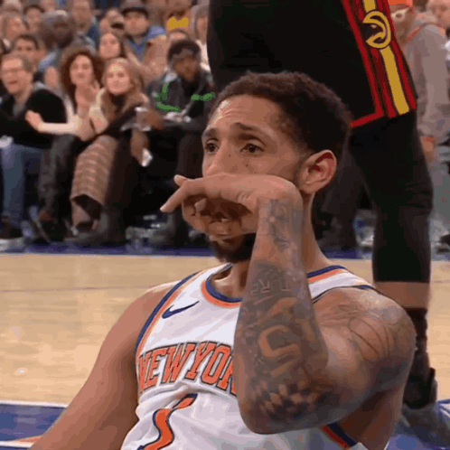 A Basketball Player Wearing A New York Jersey Wipes His Face GIF