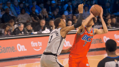 A Basketball Player Wearing A Number 1 Jersey Tries To Block Another Player GIF