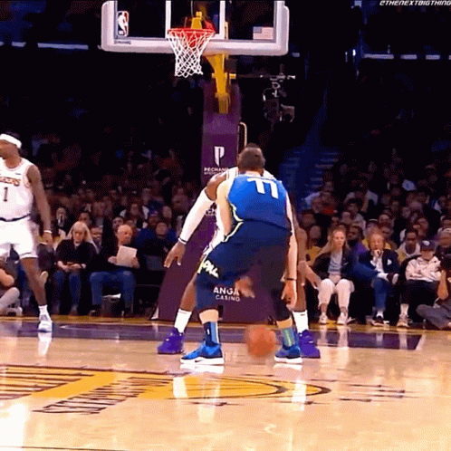 A Basketball Player Wearing A Number 11 Jersey Dribbles The Ball GIF