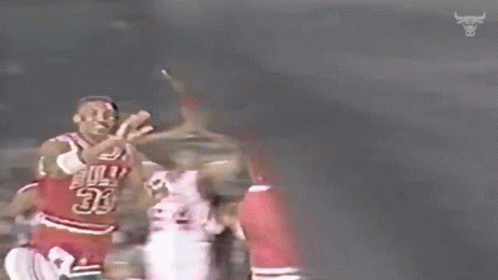 a basketball player wearing a number 23 jersey is giving another player a high five .