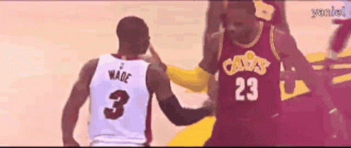 a basketball player wearing a number 23 jersey talks to another player wearing a number 3 jersey