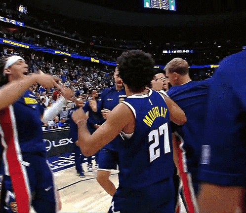 A Basketball Player Wearing A Number 27 Jersey Is Surrounded By His Teammates GIF
