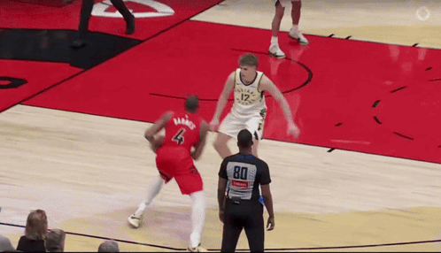 a basketball player wearing a number 4 jersey tries to block a player wearing a number 12 jersey