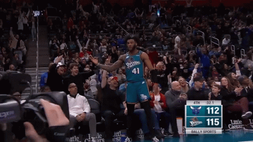 A Basketball Player Wearing A Number 41 Jersey Stands In Front Of A Crowd GIF