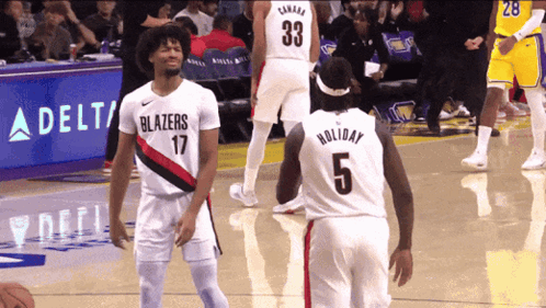 A Basketball Player Wearing A Number 5 Jersey Talks To Another Player Wearing A Number 33 Jersey GIF