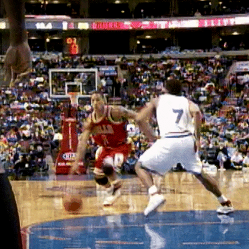 A Basketball Player Wearing A Number 7 Jersey Dribbles The Ball GIF
