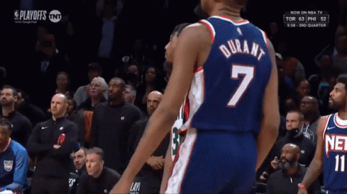 A Basketball Player Wearing A Number 7 Jersey Stands In Front Of A Crowd GIF