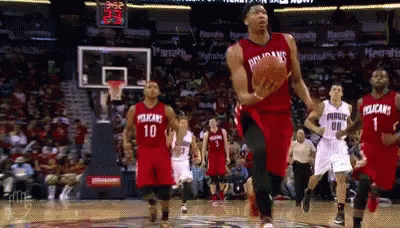A Basketball Player Wearing A Pelican Jersey Is Jumping In The Air With The Ball GIF