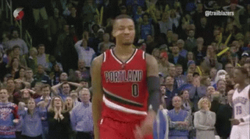 a basketball player wearing a portland jersey is standing in front of a crowd