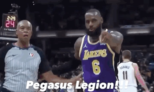 A Basketball Player Wearing A Purple Lakers Jersey Shakes Hands With A Referee During A Game . GIF