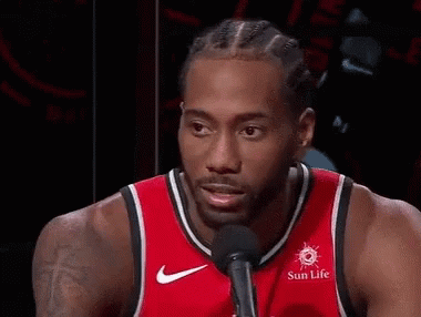 A Basketball Player Wearing A Red Jersey Is Smiling And Talking Into A Microphone . GIF