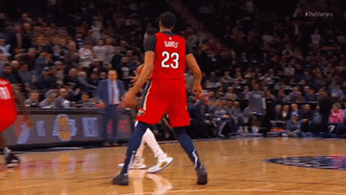 A Basketball Player Wearing A Red Jersey With The Number 23 On It Is Standing On The Court . GIF