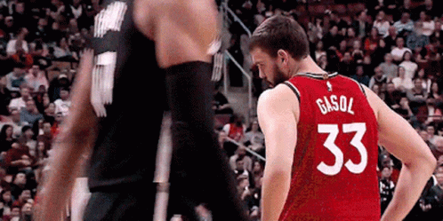 A Basketball Player Wearing A Red Jersey With The Number 33 On The Back Is Standing Next To Another Player . GIF