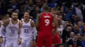 A Basketball Player Wearing A Red Jersey With The Number 9 On It Stands In Front Of A Crowd . GIF