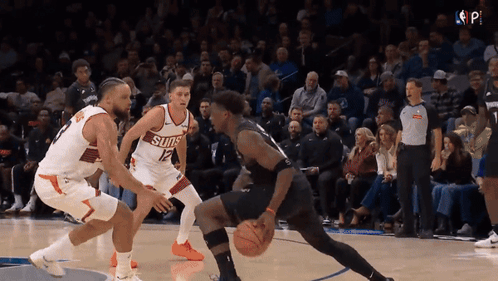 A Basketball Player Wearing A Suns Jersey Dribbles The Ball GIF