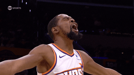 A Basketball Player Wearing A Suns Jersey Is Screaming With His Mouth Open GIF