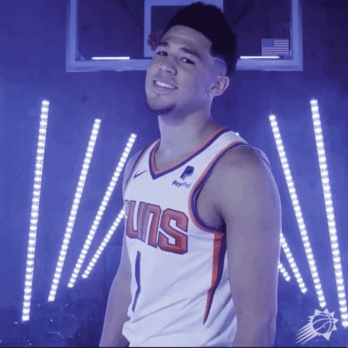 A Basketball Player Wearing A Suns Jersey Stands In Front Of A Basketball Hoop GIF