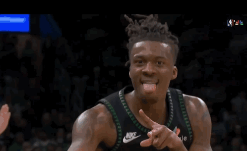 a basketball player wearing a timberwolves jersey is clapping