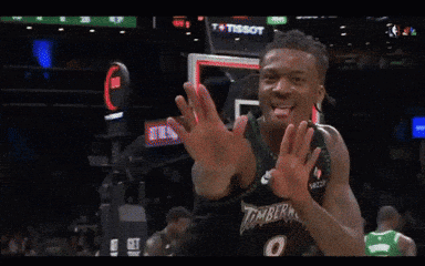 a basketball player wearing a timberwolves jersey is clapping