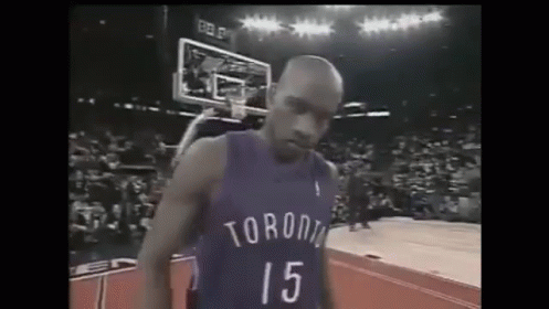 A Basketball Player Wearing A Toronto Jersey Is Standing On A Basketball Court . GIF