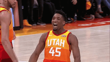 A Basketball Player Wearing A Utah Jersey Is Laughing On The Court GIF