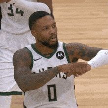 a basketball player wearing a white and green jersey with the number 0 on it .
