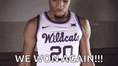 a basketball player wearing a white and purple wildcats jersey