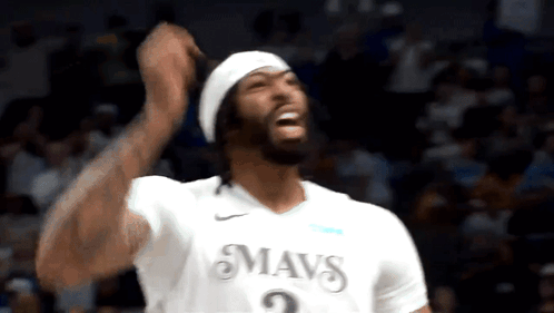 A Basketball Player Wearing A White Mavs Jersey Is Celebrating GIF