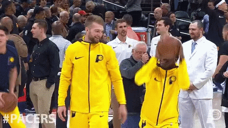 A Basketball Player Wearing A Yellow Jacket With The Letter P On It Is Holding A Basketball GIF
