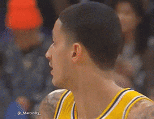 A Basketball Player Wearing A Yellow Jersey Is Looking At Something GIF