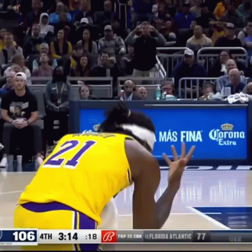 A Basketball Player Wearing A Yellow Jersey With The Number 21 GIF