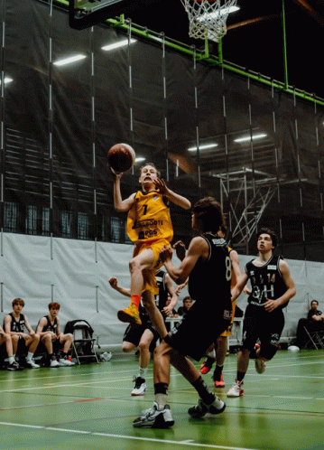 A Basketball Player Wearing A Yellow Jersey With The Number 7 On It Is Jumping In The Air GIF