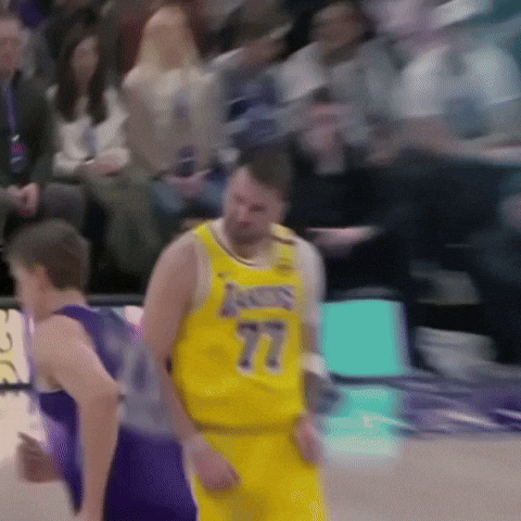 A Basketball Player Wearing A Yellow Jersey With The Number 77 GIF