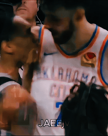 A Basketball Player Wearing An Oklahoma City Jersey Is Talking To Another Player GIF