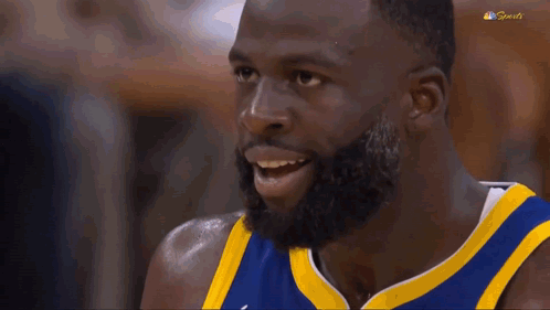 a basketball player with a beard is making a funny face with his mouth open .