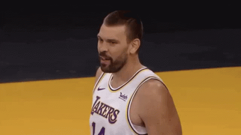 A Basketball Player With A Beard Wearing A Lakers Jersey Is Standing On A Court . GIF