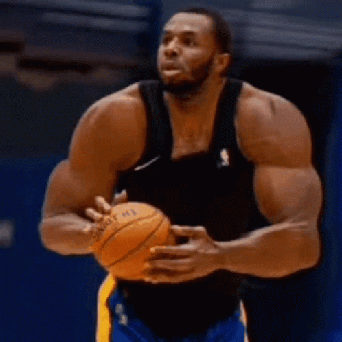 A Basketball Player With A Lot Of Muscles Is Holding A Basketball In His Hands . GIF
