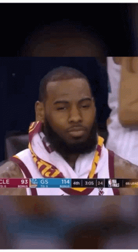 a basketball player with a towel around his neck is sitting in the stands