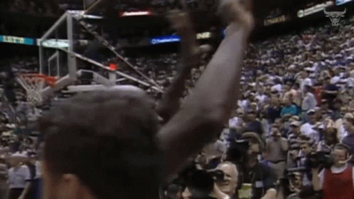 A Basketball Player With His Arms In The Air In Front Of A Crowd With A Scoreboard That Says 11:52 GIF