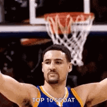 A Basketball Player With His Arms Outstretched In Front Of A Basketball Hoop . GIF
