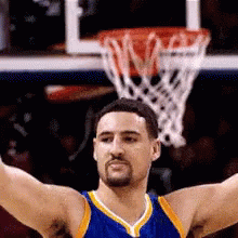 A Basketball Player With His Arms Outstretched In Front Of The Net GIF